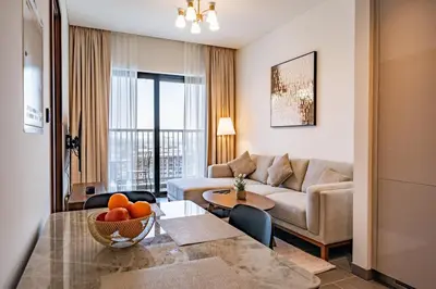 a living room with a couch and a table at Brand New 1 Bedroom Apartment in Sobha Hartland Dubai in Dubai