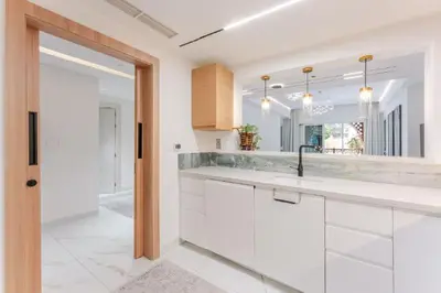 a white kitchen with a sink and a mirror at Luxury Apartment in Palm Jumeirah, Breathtaking Sea Views in Dubai
