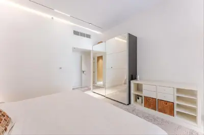 a white bedroom with a large bed and a mirror at Luxury Apartment in Palm Jumeirah, Breathtaking Sea Views in Dubai