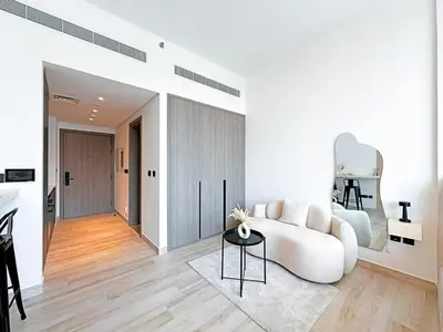 a living room with a white couch and a table at Stylish Contemporary Studio in Oxford Gardens in Dubai