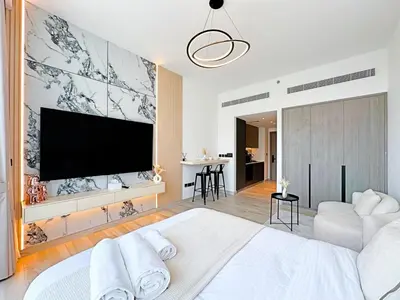 a bedroom with a large television on a wall at Stylish Contemporary Studio in Oxford Gardens in Dubai