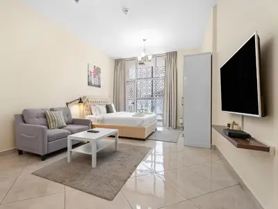 a living room with a couch and a tv at The Cozy Corner Studio In Chaimaa in Dubai