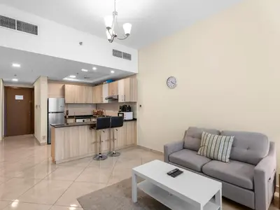 a living room with a couch and a kitchen at The Cozy Corner Studio In Chaimaa in Dubai