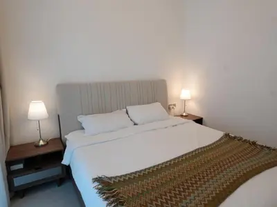 a bedroom with a large white bed with two lamps at Urban Oasis by Missoni in Dubai