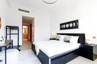 a bedroom with a large bed and a desk at Spacious 1B in Palm Close to Palm Mall in Dubai