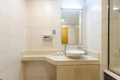 a bathroom with a sink and a tub and a mirror at Spacious 1B in Palm Close to Palm Mall in Dubai