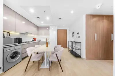 a kitchen with a table and chairs in a room at Elegant 1BR Near Downtown Azizi Riviera 3 in Dubai