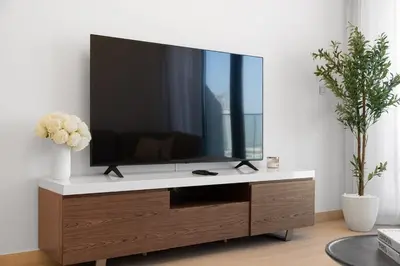 a television on a cabinet in a living room at Elegant 1BR Near Downtown Azizi Riviera 3 in Dubai