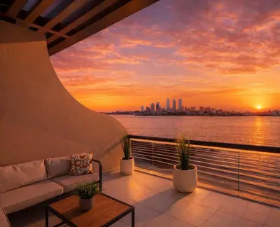 a balcony with a couch and a sunset at LUX Seaview Studio - Beach Access in Dubai
