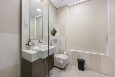 a bathroom with a sink and a toilet and a mirror at LUX Seaview Studio - Beach Access in Dubai