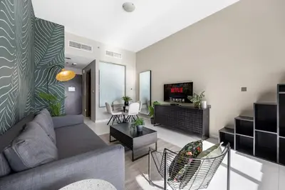 a living room with a couch and a tv at LUX Seaview Studio - Beach Access in Dubai