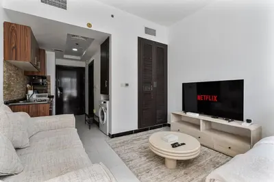 a living room with a couch and a flat screen tv at Chic Studio in JVC near Stadium and Miracle Garden in Dubai
