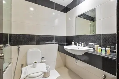 a bathroom with a white toilet and a sink at Chic Studio in JVC near Stadium and Miracle Garden in Dubai