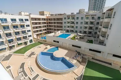 an overhead view of an apartment complex with a swimming pool at Chic Studio in JVC near Stadium and Miracle Garden in Dubai