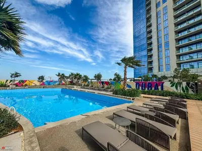 a swimming pool with lounge chairs next to a building at Dubai Business Bay Modern Cozy Studio with Skyline Views & Lagoon Pool Access in Dubai