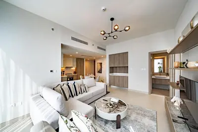 a living room with a white couch and a table at Homes Beyond l Marina Luxe 1BR at LIV in Dubai