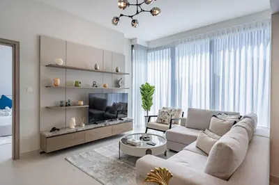 a living room with a couch and a tv at Homes Beyond l Marina Luxe 1BR at LIV in Dubai