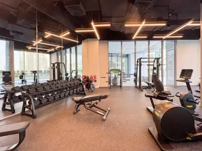 a gym with several treadmills and machines in it at Homes Beyond l Marina Luxe 1BR at LIV in Dubai