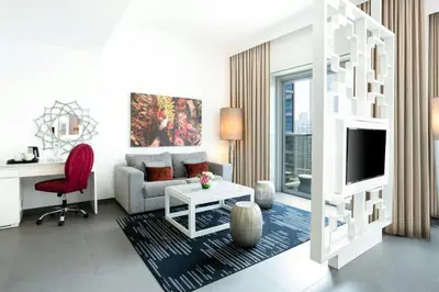 a white living room with a couch and a desk at The First Collection Marina, Dubai, a Tribute Portfolio Hotel in Dubai