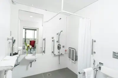 a white bathroom with a sink and a shower at The First Collection Marina, Dubai, a Tribute Portfolio Hotel in Dubai