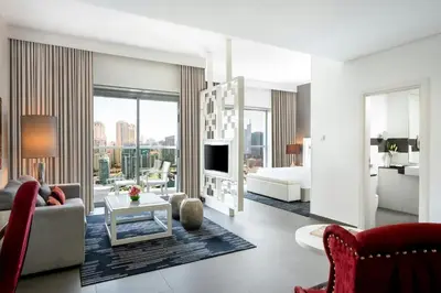 a living room with a couch and a bed and a television at The First Collection Marina, Dubai, a Tribute Portfolio Hotel in Dubai