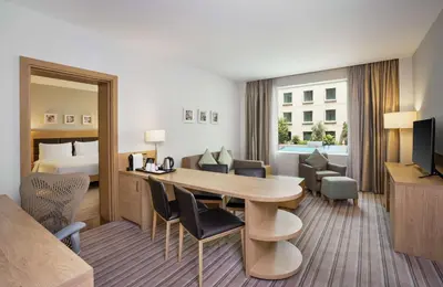 a hotel room with a table and a bed at Hilton Garden Inn Dubai, Mall Avenue in Dubai