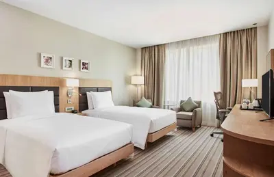 a hotel room with two beds and a desk at Hilton Garden Inn Dubai, Mall Avenue in Dubai