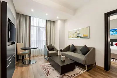 a living room with a couch and a chair and a table at Ramada by Wyndham Dubai Barsha Heights in Dubai
