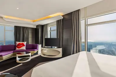 a hotel room with a bed and a tv at V Hotel Dubai, Curio Collection by Hilton in Dubai