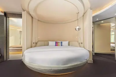 a large white bed in a room at V Hotel Dubai, Curio Collection by Hilton in Dubai