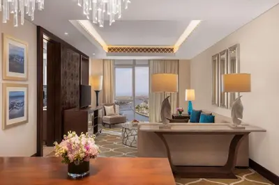 a living room with a desk and a living room with a view at Hilton Dubai Al Habtoor City in Dubai