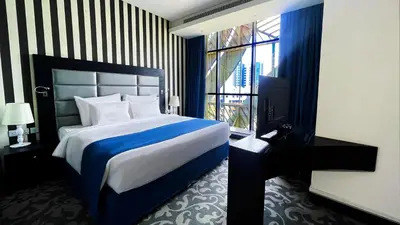 a bedroom with a large bed and a window at Signature 1 Hotel Tecom in Dubai