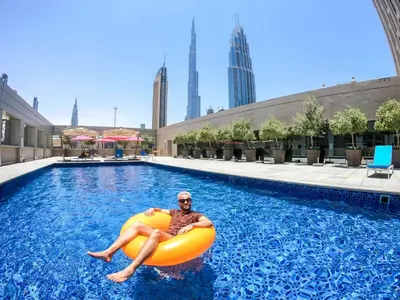 a man is laying on an inflatable pool in a swimming pool at Rove Downtown in Dubai