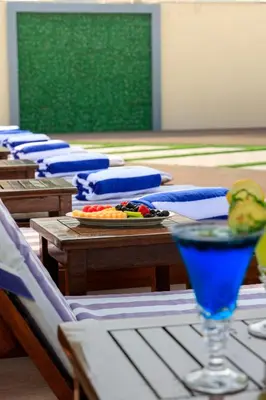 a table with chairs and a blue drink on it at MD Hotel By Gewan in Dubai