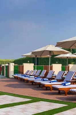 a row of lounge chairs and umbrellas on a patio at MD Hotel By Gewan in Dubai