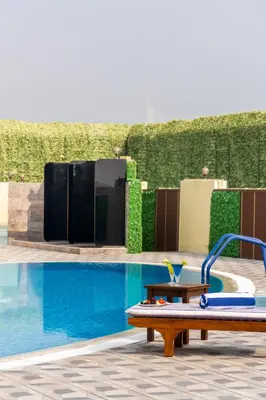 a swimming pool with a table next to a swimming pool at MD Hotel By Gewan in Dubai