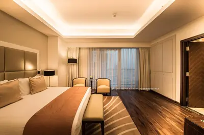 a hotel room with a bed and a large window at La Suite Dubai Hotel & Apartments in Dubai