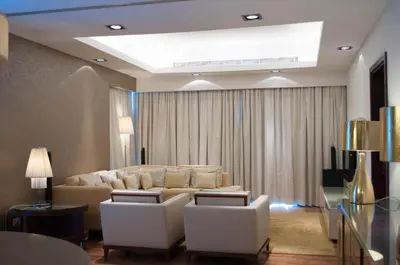 a living room with a couch and white chairs at La Suite Dubai Hotel & Apartments in Dubai