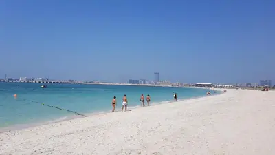 a group of people walking on the beach at Luxury Sea View Beachfront 3 Bedroom Apt, JBR in Dubai