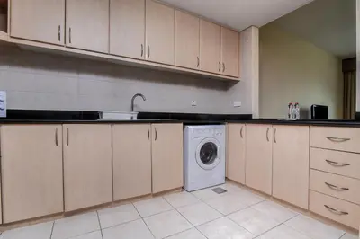 a kitchen with a washer and a washing machine at Parkside Hotel Apartment in Dubai