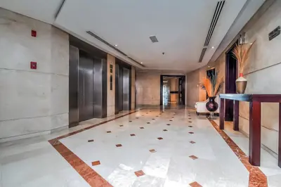 a hallway with a large tile floor and a long corridor at Parkside Hotel Apartment in Dubai