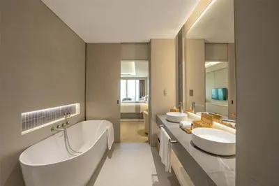a bathroom with two sinks and a large mirror at The Meydan Hotel Dubai in Dubai