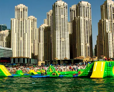 a group of people riding on an inflatable slide in the water at One Bedroom Apartment - Bay Central Tower in Dubai