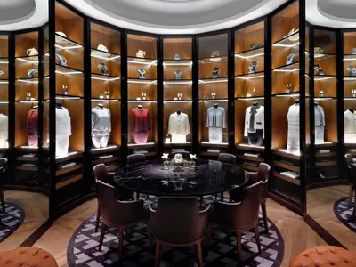 a dressing room with a table and chairs and a wall of shelves at Kempinski The Boulevard Dubai in Dubai
