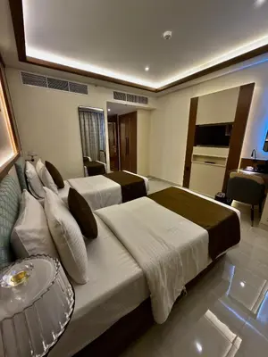 a hotel room with two beds and a table at Smana Hotel Al Raffa in Dubai