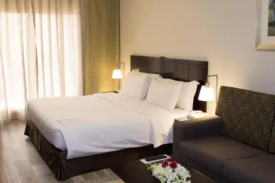 a hotel room with a large bed and a couch at Savoy Crest Hotel Apartments in Dubai