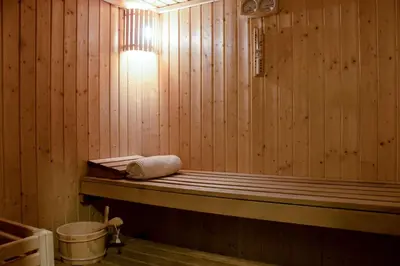 a wooden bath tub with a towel sitting in it at Savoy Crest Hotel Apartments in Dubai