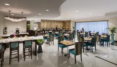 a restaurant with tables and chairs with people in the background at Savoy Crest Hotel Apartments in Dubai