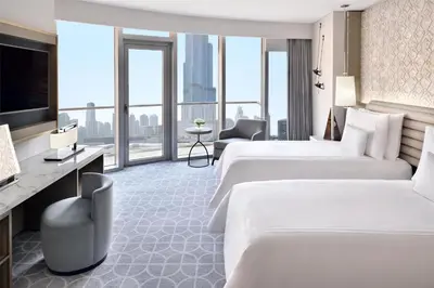 a hotel room with two beds and a large window at Kempinski Central Avenue Dubai in Dubai