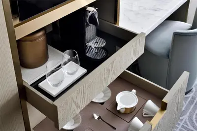 a drawer with two glasses and plates in a cabinet at Kempinski Central Avenue Dubai in Dubai